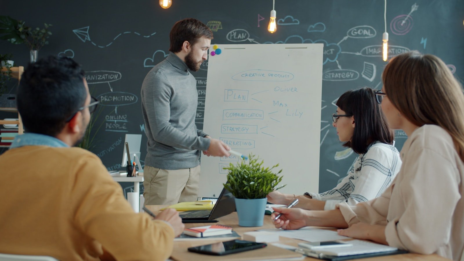 Team discussing a marketing strategy around a whiteboard in a modern office